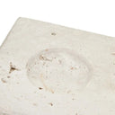 A square-shaped sculpture made of travertine limestone with a fibrous texture, displayed on a white square base.