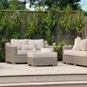 Wicker two seater outdoor sofa with cream plush cushions