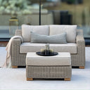 Wicker two seater outdoor sofa with cream plush cushions