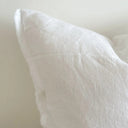A white linen cushion cover with a zipper closure.